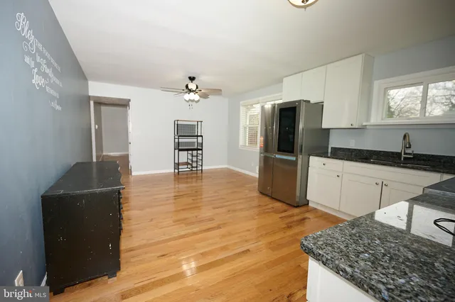a kitchen with granite countertop a refrigerator and a stove top oven