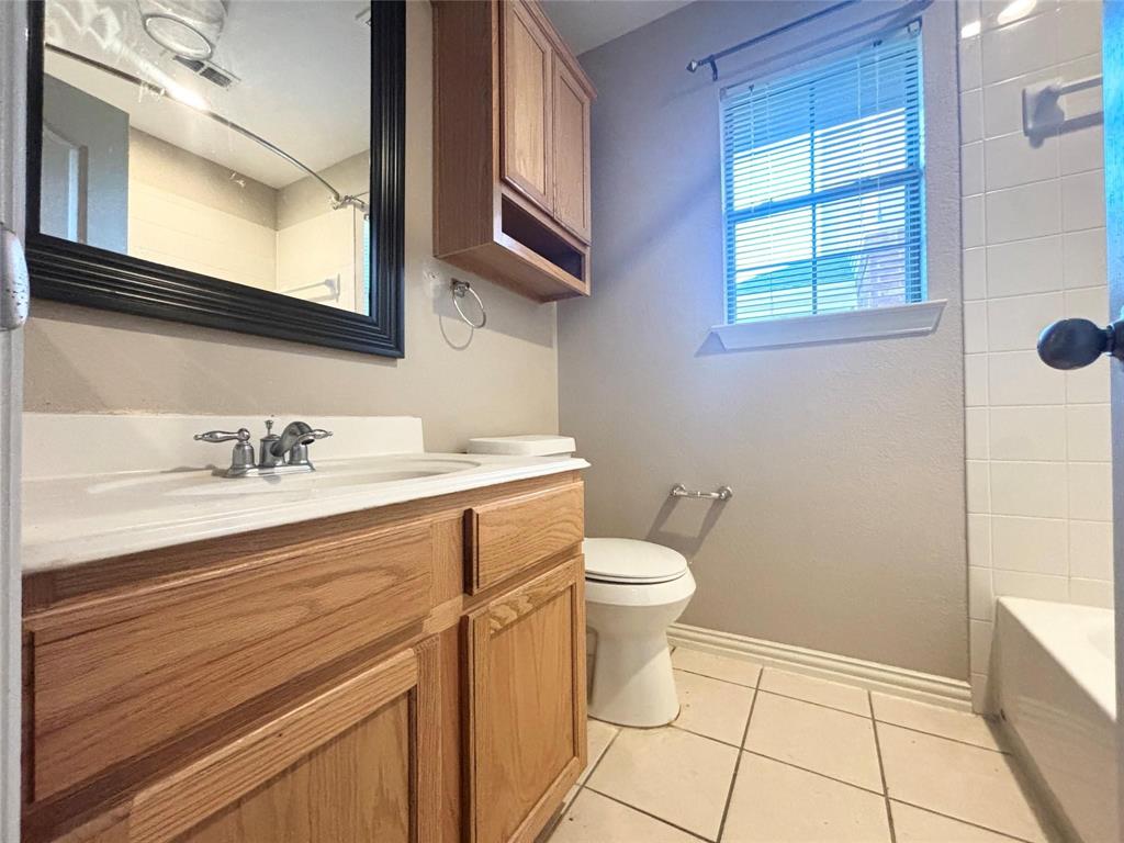 9416 Harrell Drive McKinney, TX 75072 - Photo 12 of 16 a bathroom with a sink a toilet and a window