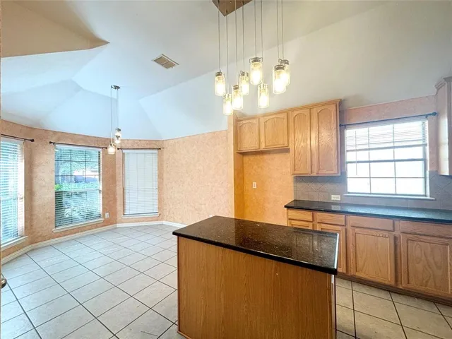 a kitchen with stainless steel appliances granite countertop a sink window and cabinets