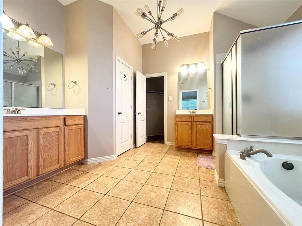 9416 Harrell Drive McKinney, TX 75072 - Photo 10 of 16 a bathroom with a tub a sink and a large mirror