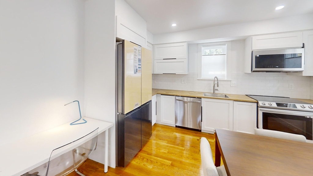 36 Shepard Street, Unit 1 Boston, MA 02135 - Photo 25 of 29 a kitchen with stainless steel appliances granite countertop a sink and a stove top oven
