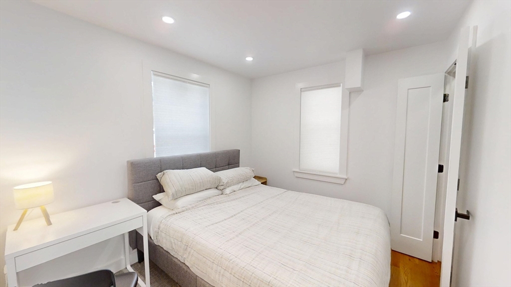 36 Shepard Street, Unit 1 Boston, MA 02135 - Photo 8 of 29 a bedroom with a bed and a table in it