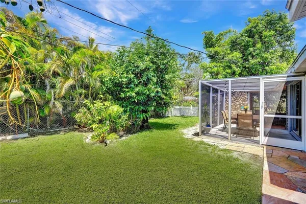 a view of a backyard with table and chairs and potted plants