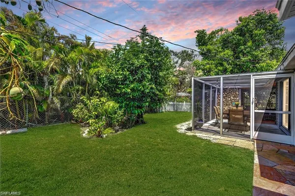 a view of a backyard with table and chairs and potted plants