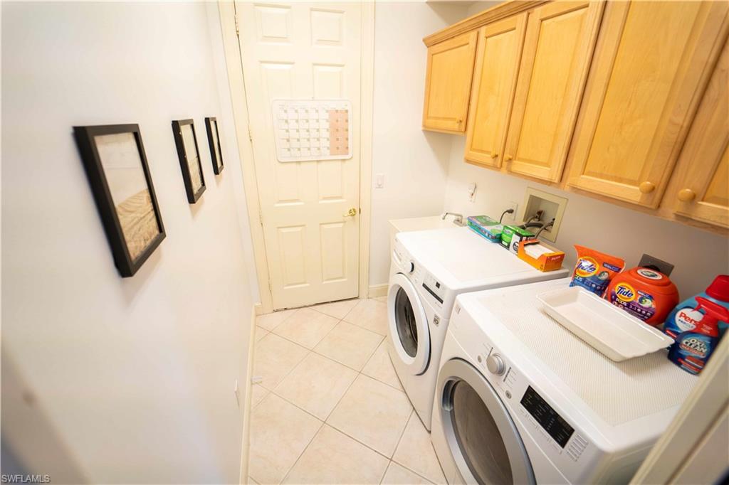 5886 Paradise Circle Naples, FL 34110 - Photo 15 of 19 Washroom featuring light tile patterned floors, independent washer and dryer, and cabinets