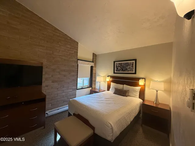 a bedroom with a bed and a television