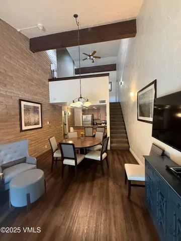 a dining room with wooden floor a glass table and chairs