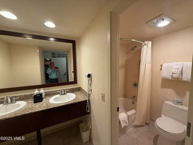 a bathroom with a sink vanity mirror and toilet