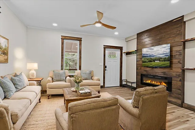 a living room with furniture large window and a flat screen tv
