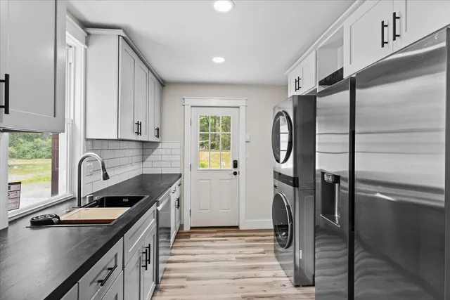 a kitchen with stainless steel appliances granite countertop a sink refrigerator and cabinets