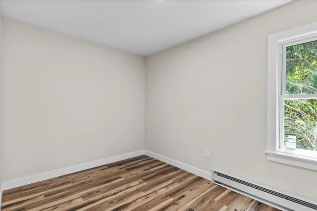 a view of a room that has wooden floor and white walls