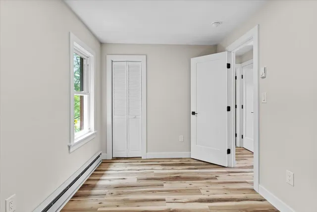 a view of a livingroom with wooden floor and window