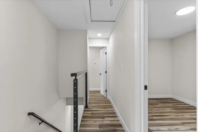 a view of a hallway with wooden floor and staircase