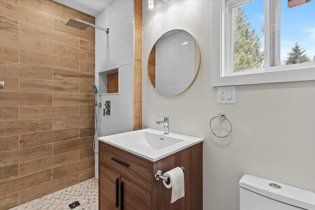 a bathroom with a sink a toilet and a mirror