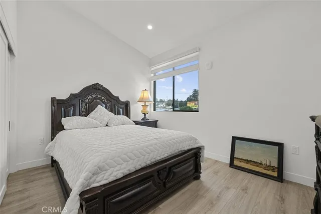 a bedroom with a bed and wooden floor