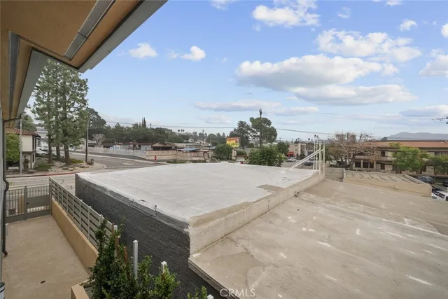 a view of a terrace with couches and wooden fence