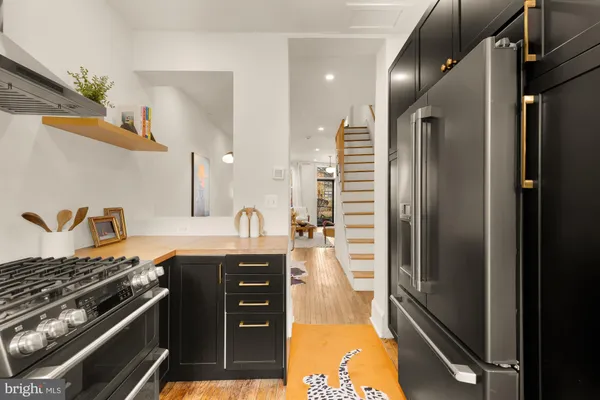 a kitchen with stainless steel appliances granite countertop a stove a refrigerator and a sink