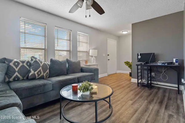 a living room with furniture and a wooden floor