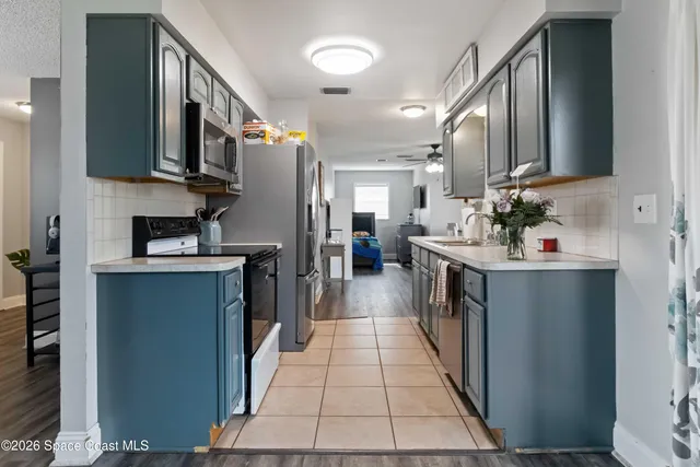 a bathroom with stainless steel appliances a sink and a refrigerator