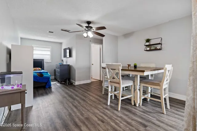 a dining room with furniture a chandelier and wooden floor