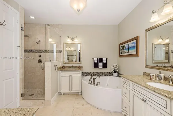 a bathroom with a granite countertop tub sink and mirror