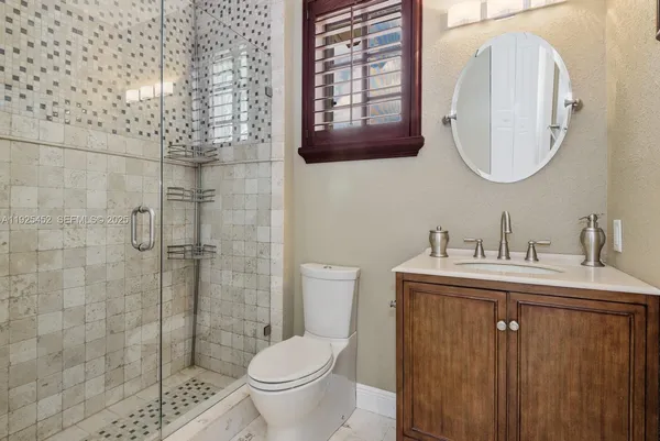a bathroom with a granite countertop sink a toilet and a mirror