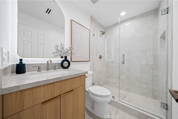 a bathroom with a sink toilet a mirror and shower