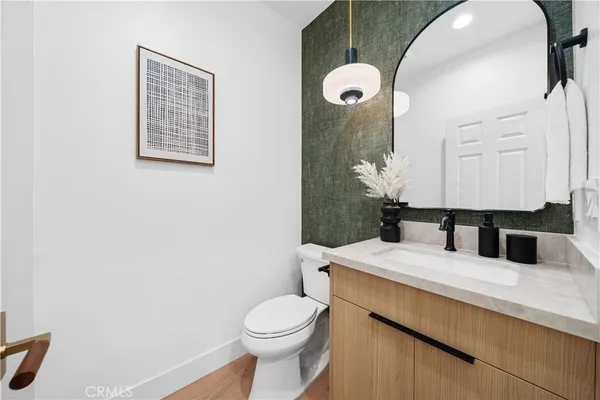 a bathroom with a granite countertop sink mirror vanity and toilet