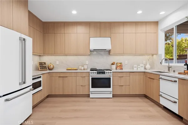a kitchen with granite countertop a sink stainless steel appliances and cabinets