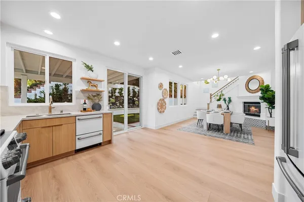 a large white kitchen with stainless steel appliances kitchen island granite countertop a sink and cabinets