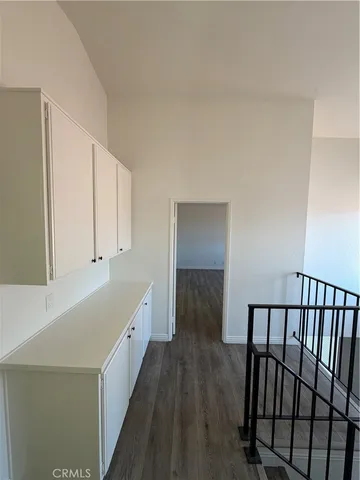 a view of a hallway with wooden floor and staircase