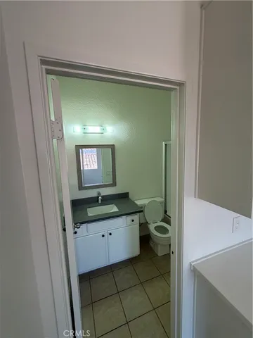 a bathroom with a granite countertop sink a toilet and a mirror