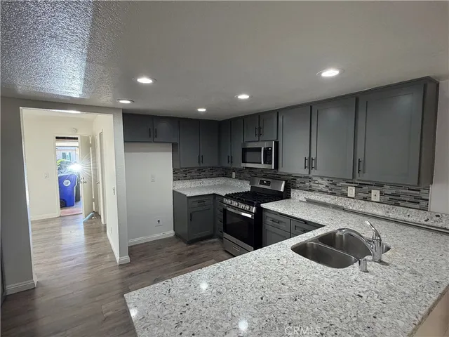 a kitchen with stainless steel appliances granite countertop a sink stove and refrigerator