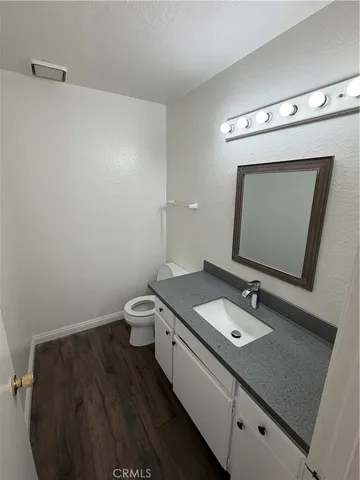 a bathroom with a granite countertop sink a toilet and a mirror