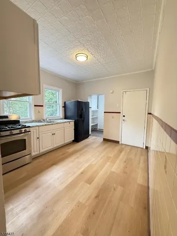 a kitchen with a stove a refrigerator and cabinets