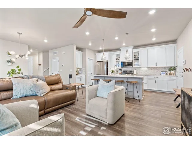 a kitchen with stainless steel appliances a sink a stove a refrigerator cabinets and a dining table