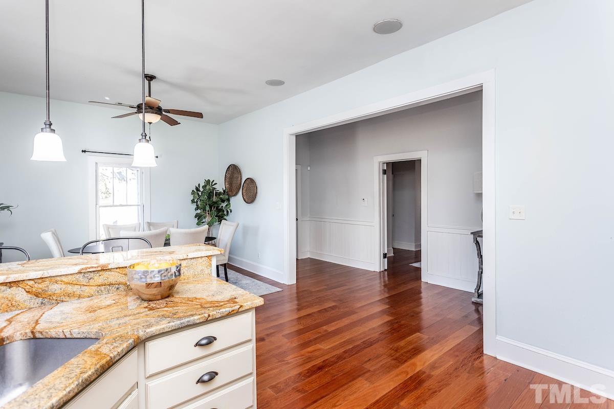 529 East Martin Street Raleigh, NC 27601 - Photo 13 of 29 a living room with kitchen island granite countertop wooden floor and a ceiling fan