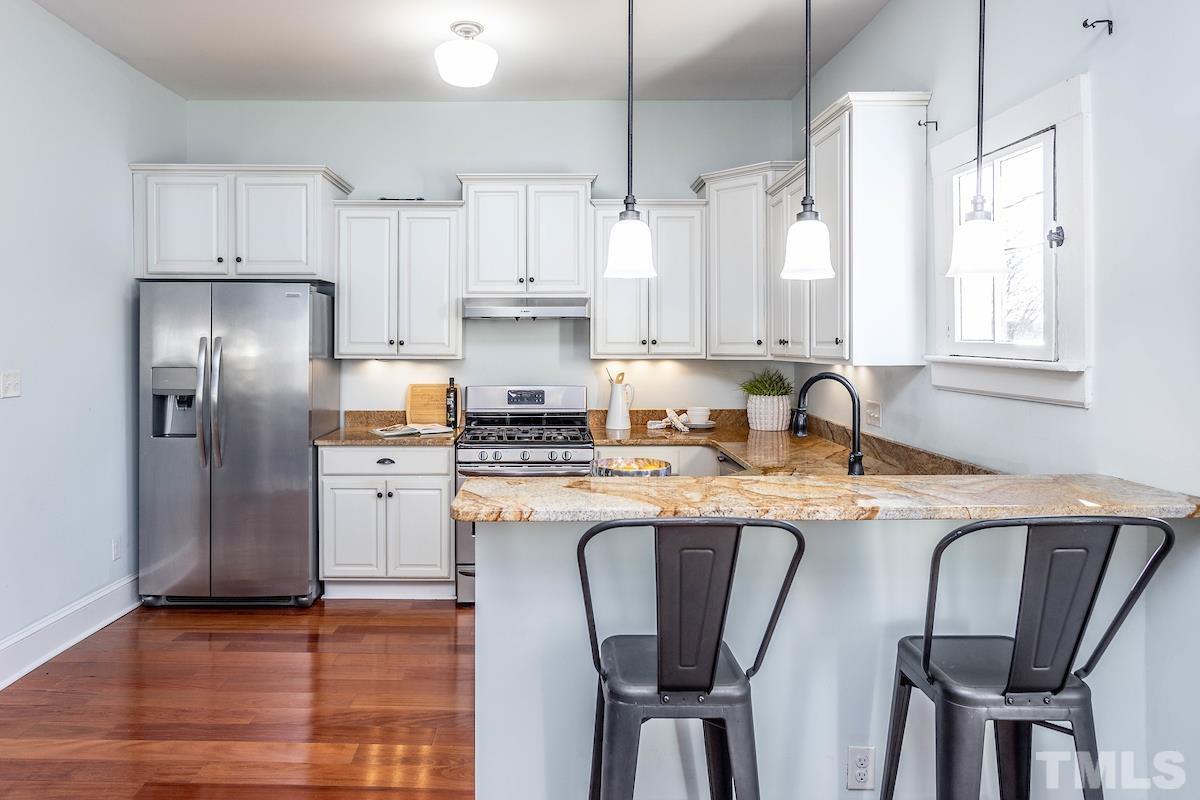 529 East Martin Street Raleigh, NC 27601 - Photo 14 of 29 a kitchen with stainless steel appliances granite countertop a dining table chairs refrigerator and cabinets