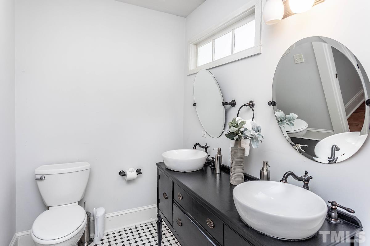 529 East Martin Street Raleigh, NC 27601 - Photo 19 of 29 a bathroom with a toilet a sink and mirror