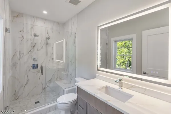 an empty room with wooden floor & windows and bathroom
