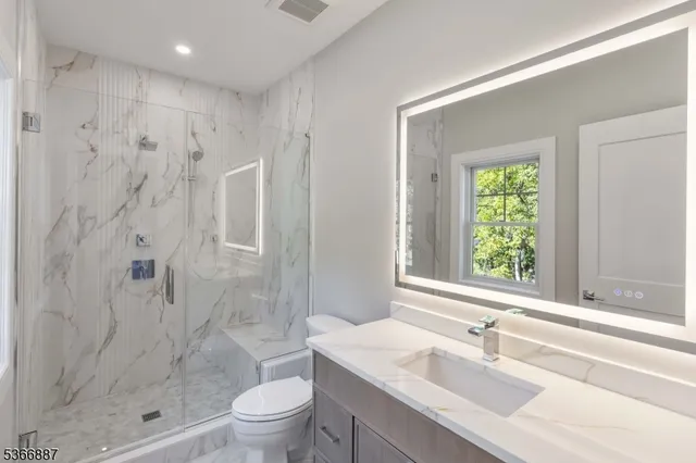an empty room with wooden floor & windows and bathroom