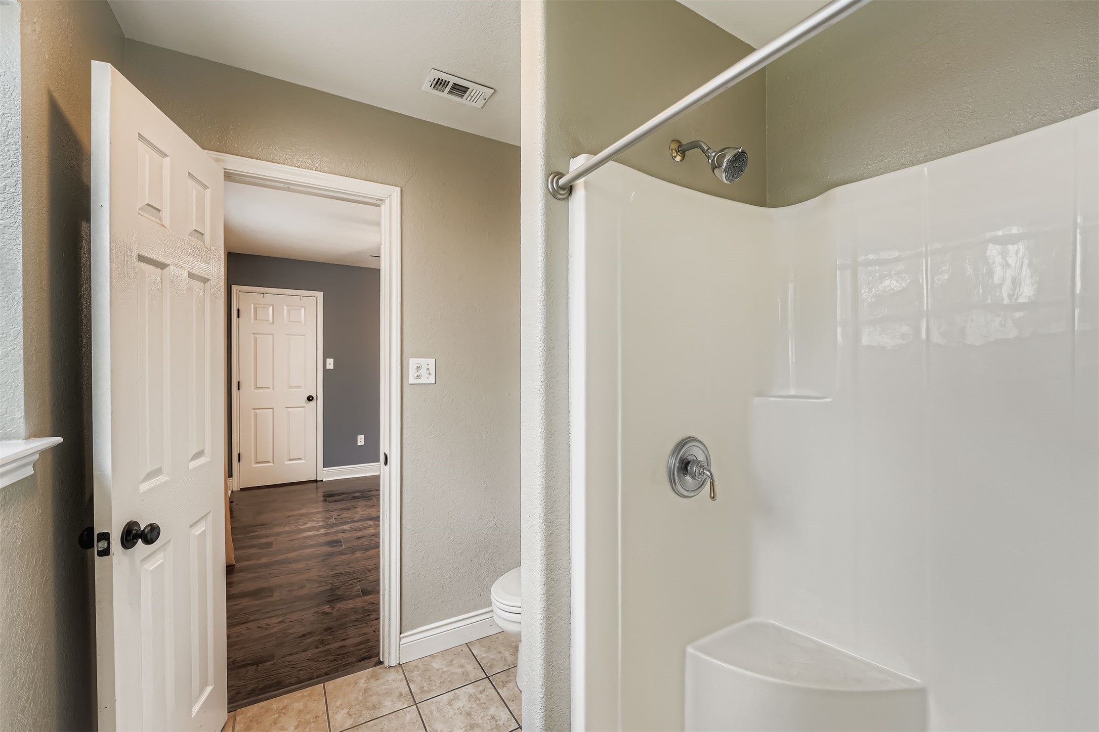 304 South Main Street Elgin, TX 78621 - Photo 19 of 25 Bathroom with a stall shower, a textured wall, and light tile patterned floors