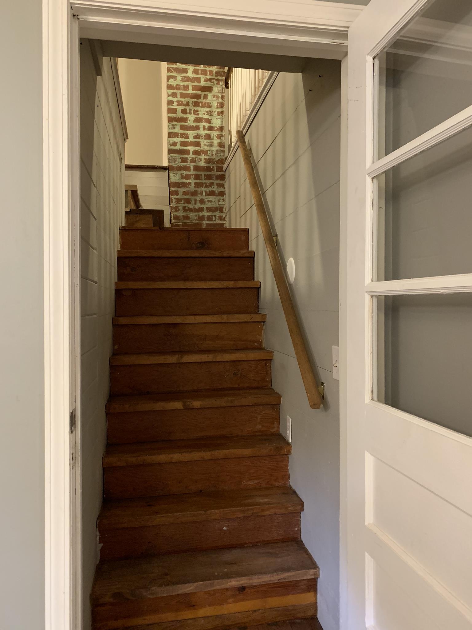 556 Central Valley Road Murfreesboro, TN 37129 - Photo 9 of 30 Staircase leading to upstairs has ship lap walls surrounding it, & a view of the exposed brick fireplace!!