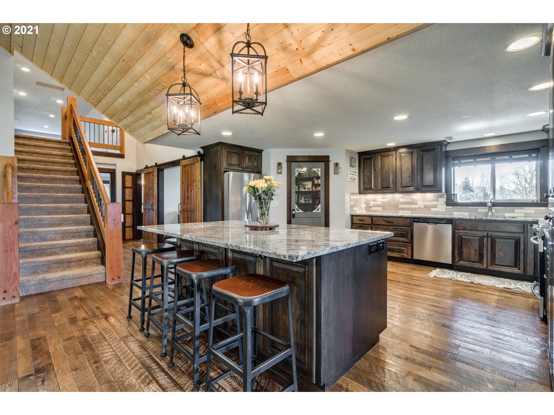 47280 Southeast Coalman Road Sandy, OR 97055 - Photo 9 of 32 a kitchen with stainless steel appliances kitchen island granite countertop a table chairs and a refrigerator