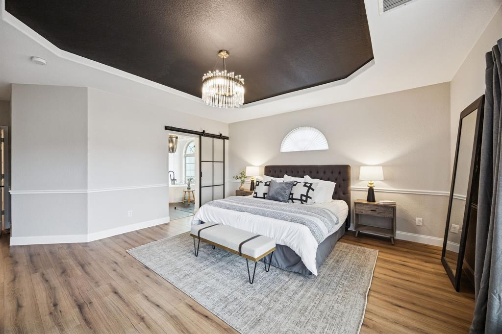 3608 Acropolis Way Plano, TX 75074 - Photo 14 of 40 a bedroom with a bed and wooden floor