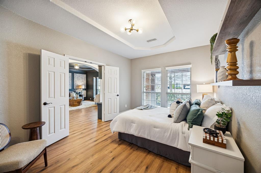 3608 Acropolis Way Plano, TX 75074 - Photo 19 of 40 a bedroom with a bed and wooden floor
