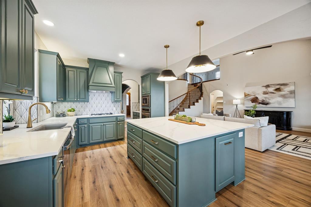 3608 Acropolis Way Plano, TX 75074 - Photo 10 of 40 a kitchen with kitchen island a sink stove and wooden floor