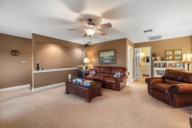 a living room with furniture and a ceiling fan