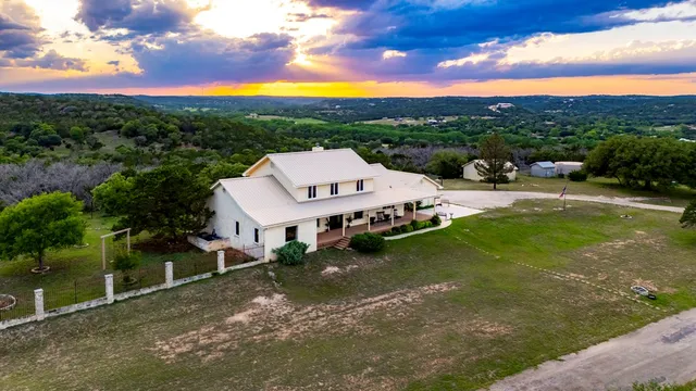 a kitchen with kitchen island granite countertop a sink cabinets and wooden floor