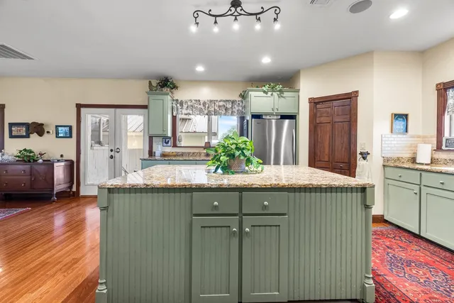 a kitchen with granite countertop lots of counter top space sink and wooden floor